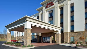A modern hotel with a stone facade, a covered entrance, and a clear blue sky. - Hampton Inn & Suites Albany-East Greenbush (East Greenbush)