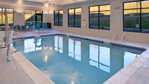 An indoor swimming pool with clear blue water, surrounded by lounge chairs and a tiled deck. - Hampton Inn & Suites Albany-East Greenbush (East Greenbush)