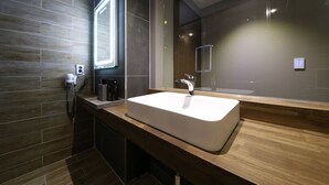 A modern bathroom with a large sink, a mirror, and a hairdryer on the counter. - Avenue Hotel (Jeonju)