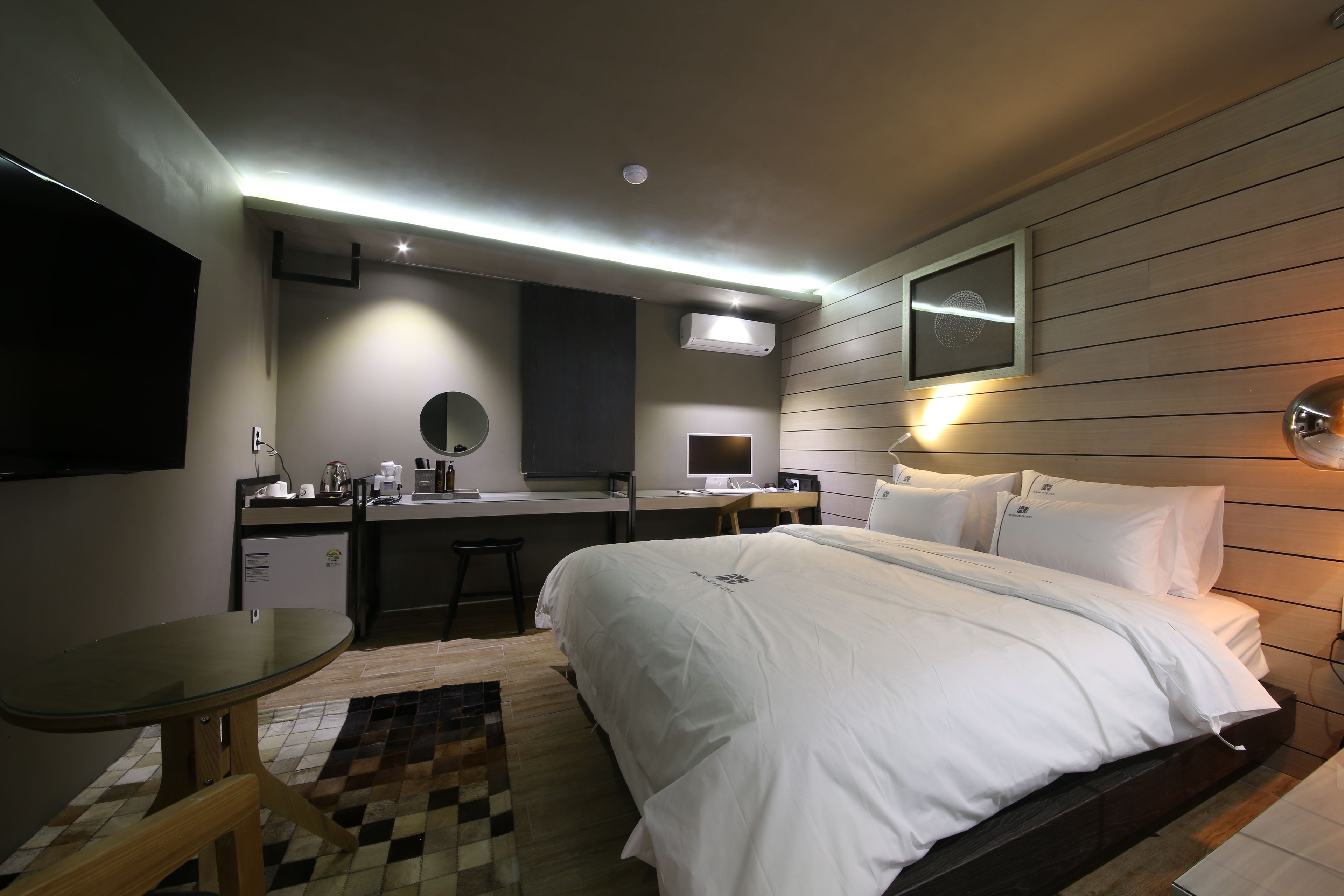 Una habitación de hotel moderna con cama, escritorio y kitchenette.