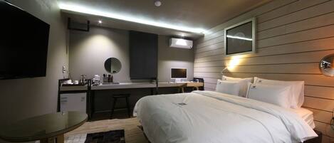 Una habitación de hotel moderna con cama, escritorio y kitchenette.