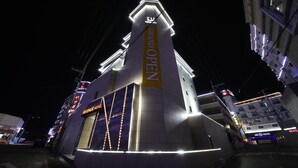 A hotel with a prominent 'Grand Open' sign, a visible entrance, and a modern architectural design. - Avenue Hotel (Jeonju)