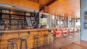 A bar area with stools, shelves with bottles, and a counter. - Palette Legian Beach (Legian)