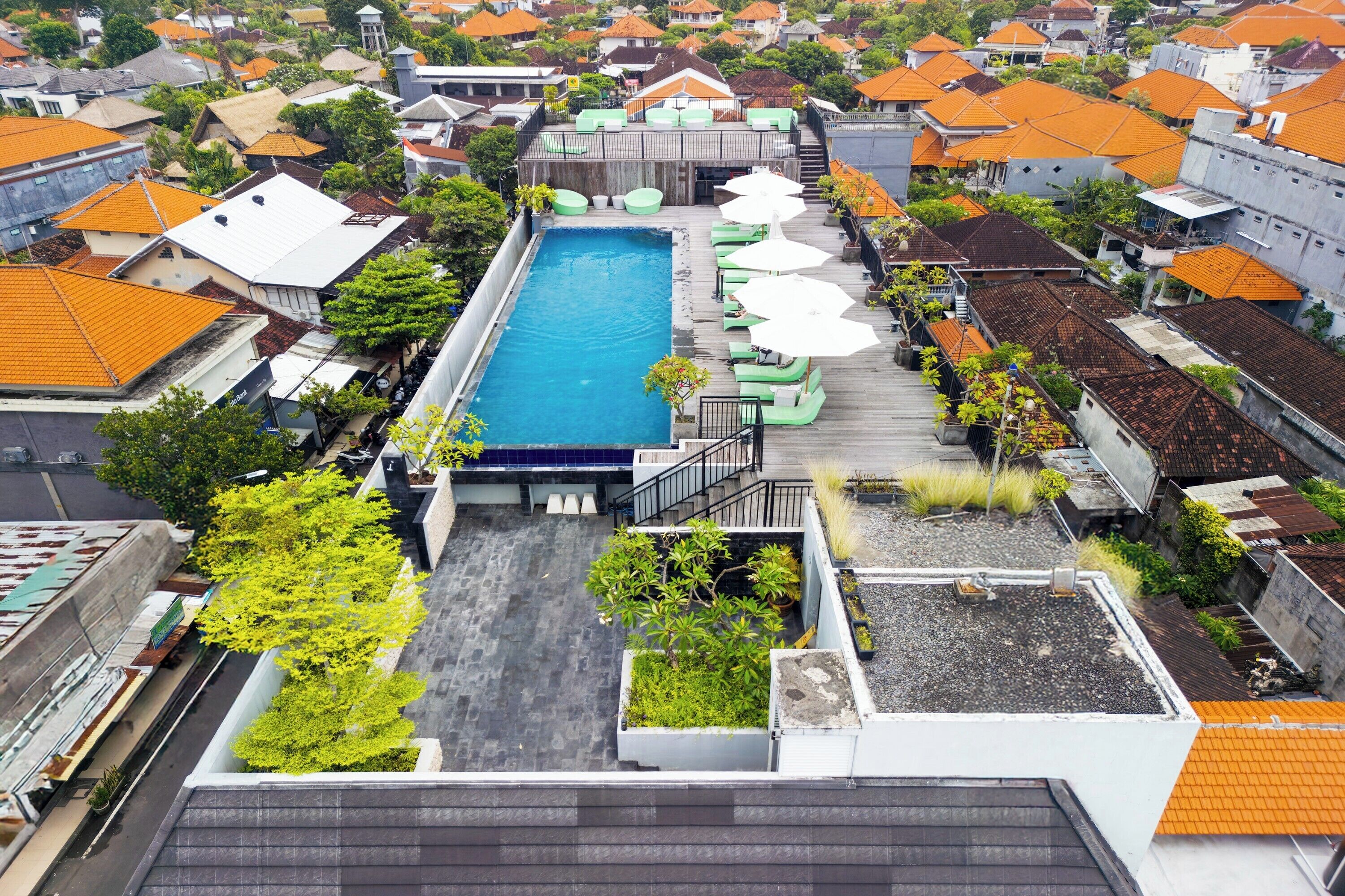 A rooftop pool with lounge chairs and a staircase leading to the pool area.