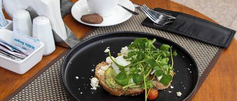 A meal with a cup of coffee, a plate of food, and a napkin on a table.