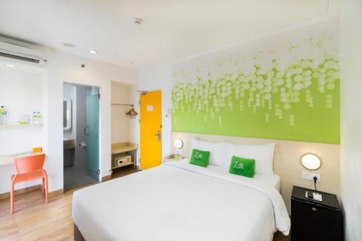 Une chambre d’hôtel avec un lit, un bureau, une chaise et une salle de bain.