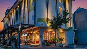 A multi-story hotel with a modern facade, large windows, and a well-lit entrance. - Palette Legian Beach (Legian)