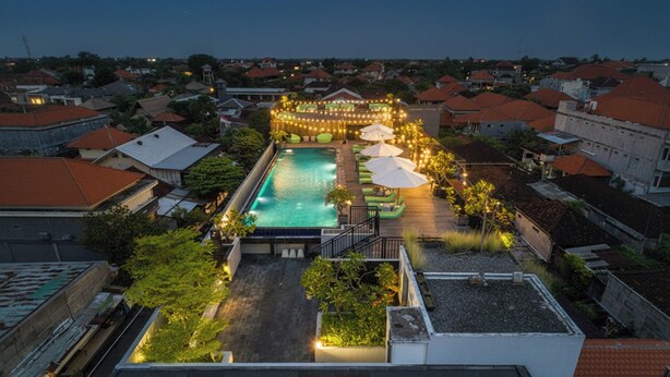 A rooftop pool with a surrounding deck, string lights, and umbrellas. - Palette Legian Beach (Legian)