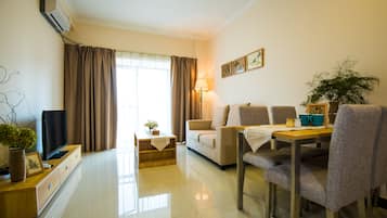 Deluxe Suite | Living area | 40-inch LCD TV with cable channels, TV, pay movies