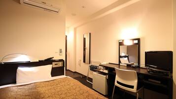 A hotel room with a bed, desk, chair, and a television.