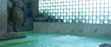 A large indoor water feature with a rocky waterfall and a tiled wall.