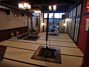 A traditional tatami mat room with a low table, chairs, and a central pillar. - Kaigetsu (Toba)