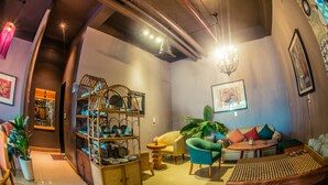 A modern interior with a sofa, chairs, a small table, and a decorative shelf. - Geminai Hotel & Cafe (Dong Hoi)