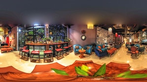 A spacious lounge area with a bar, seating arrangements, and a view through large windows. - Geminai Hotel & Cafe (Dong Hoi)