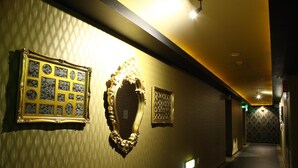 A hallway with patterned wallpaper, ornate mirrors, and recessed lighting. - Sendai Hotel Renaissance (Sendai)