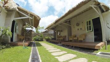 A bungalow with a thatched roof, a stone pathway, and a small garden.