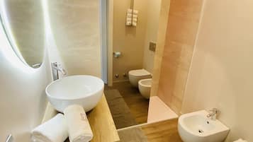 Ein modernes Badezimmer mit einem großen Spiegel, einem Holzbidet, einem Waschbecken und einer Toilette.