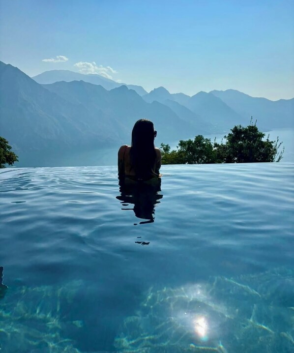 Una piscina al aire libre, sombrillas, tumbonas