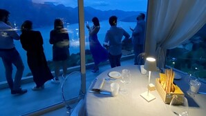 Una mesa lista para comer, con vistas a montañas y un lago.