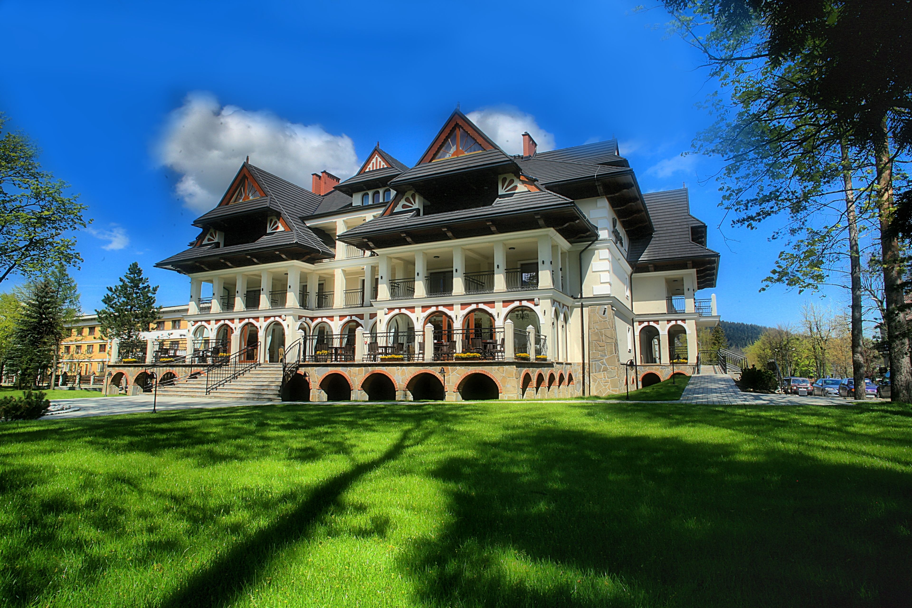 A large, multi-story building with a symmetrical facade, multiple balconies, and a central staircase leading to the upper floors.
