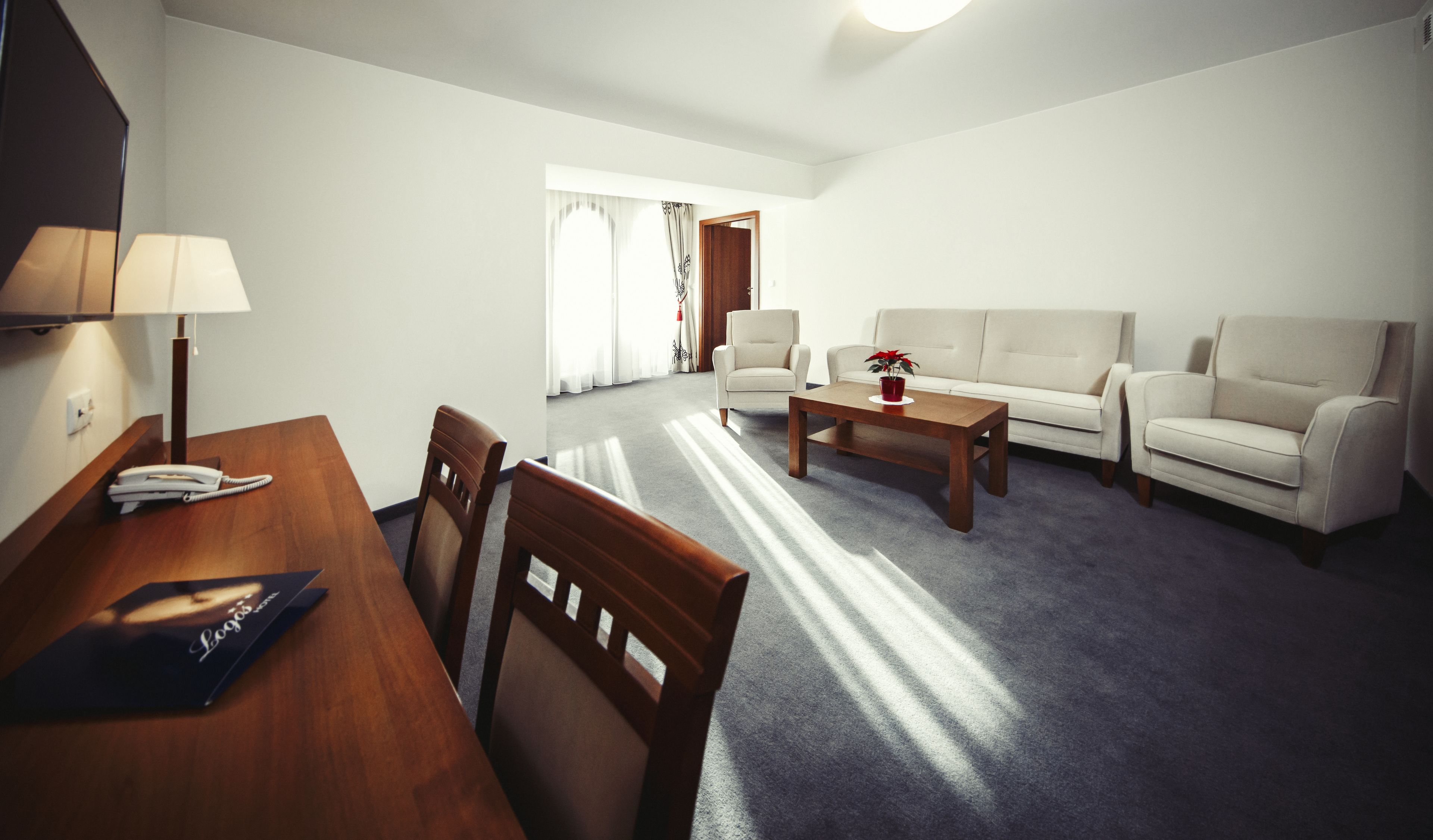 A living room with a wooden table, two chairs, a sofa, and a coffee table.