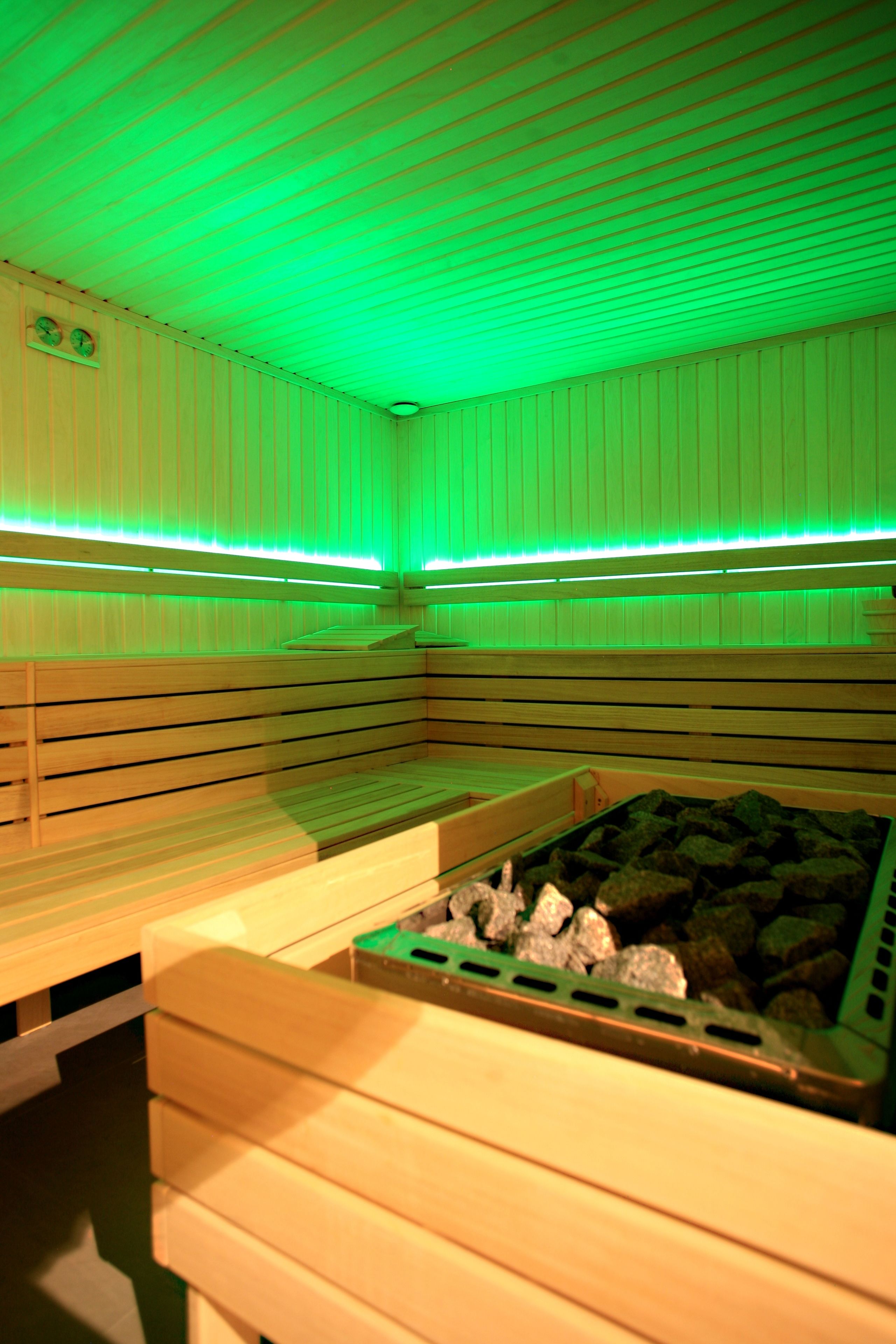 A sauna room with wooden benches and a stone basin.