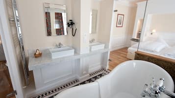 Ein modernes Badezimmer mit einer freistehenden Badewanne, zwei Waschbecken und einem großen Spiegel.