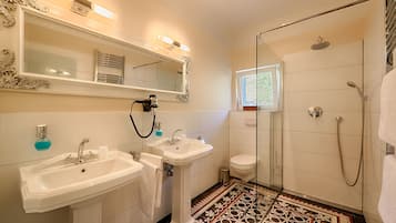 Un bagno con due lavandini, un water e una doccia.
