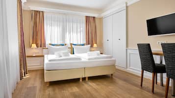 Una habitación de hotel con una cama, un escritorio y un televisor.