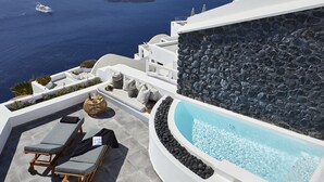 Eine Dachterrasse mit Pool, Liegestühlen und Meerblick.