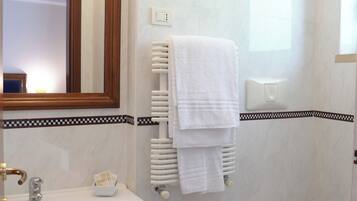 A bathroom with a sink, bidet, toilet, and a mirror.