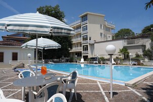 Una piscina al aire libre de temporada, sillones reclinables de piscina