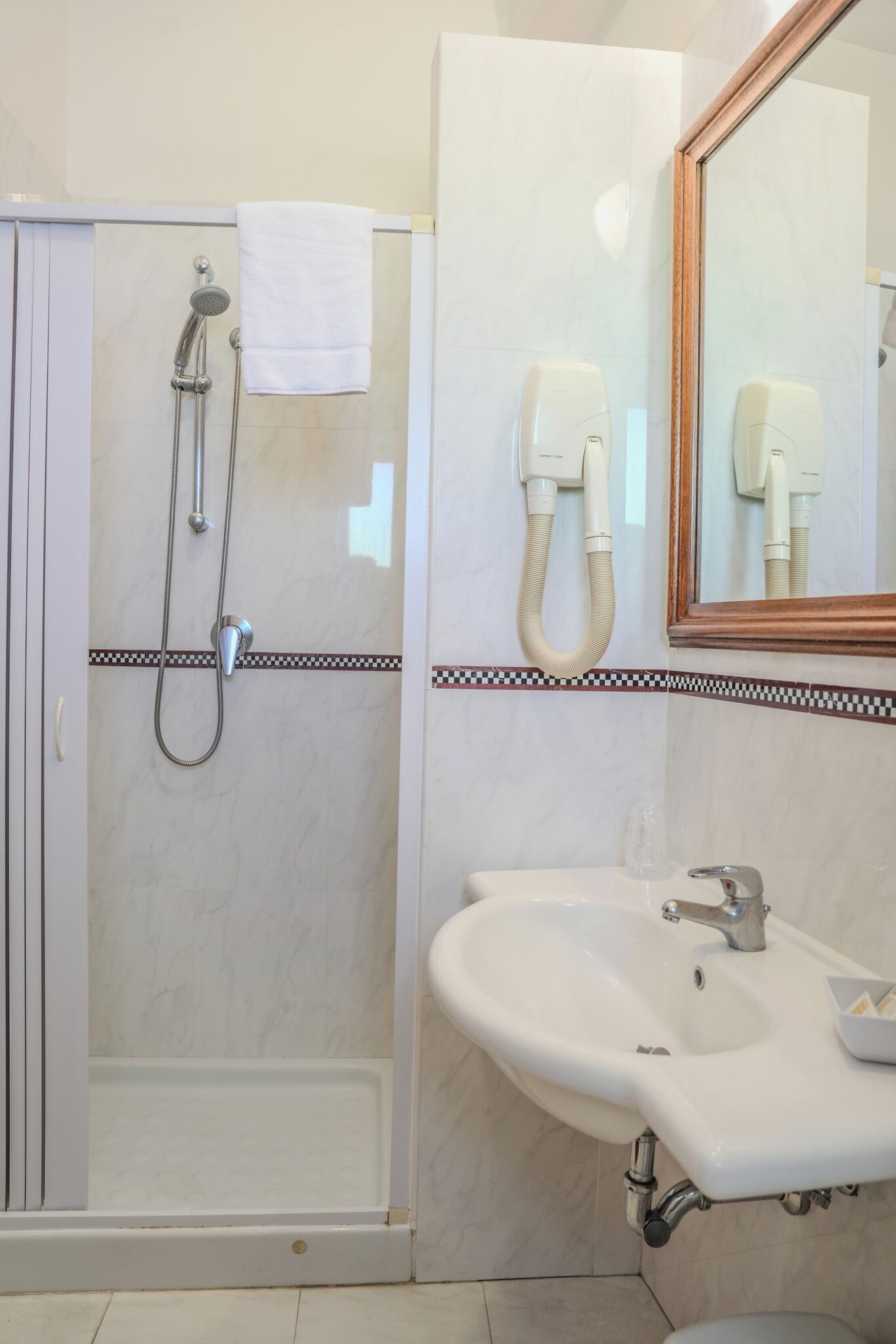 Une salle de bain avec une douche, un lavabo et un miroir.
