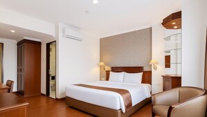 A hotel room with a large bed, a desk, a chair, and a bathroom visible through an open door. - Antares Medan (Medan)