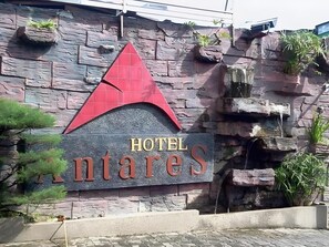 A sign for 'Hotel Montares' with a stone wall backdrop and a red triangular design above the text. - Antares Medan (Medan)