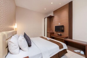 Una habitación de hotel con una cama, un televisor y un panel de pared de madera.