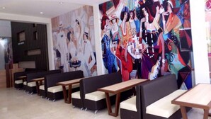 A modern interior with seating and abstract art on the walls. - City Hotel Tasikmalaya (Tasikmalaya)