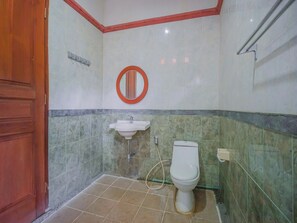 Une salle de bain avec des toilettes, un lavabo et un miroir.