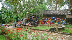 A garden with colorful murals, a stone pathway, and various plants. - OYO 89999 Hotel Bumi Kedaton Resort (Bandar Lampung)
