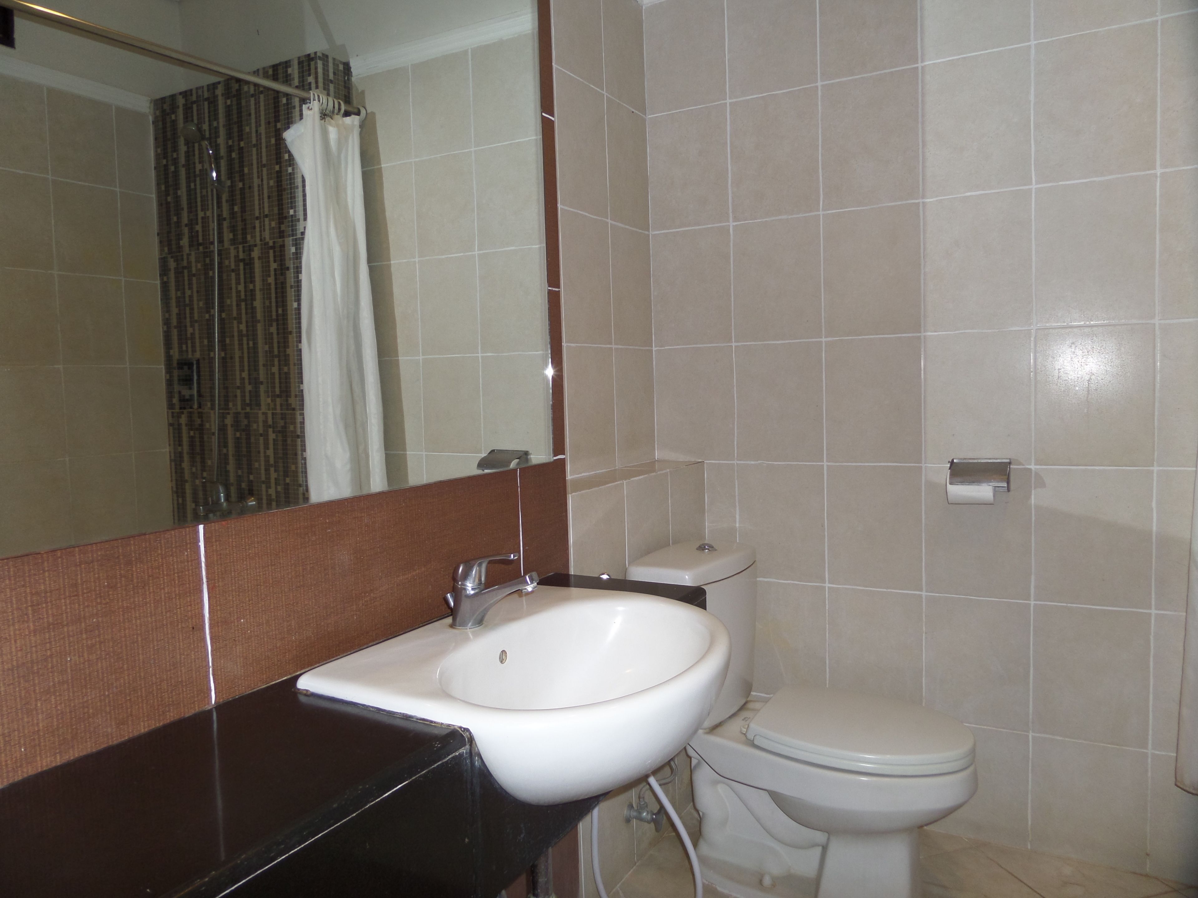 Un baño con un lavamanos blanco, un inodoro y un espejo.