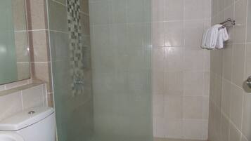 A bathroom with a toilet, a shower with a glass door, and a towel rack on the wall.