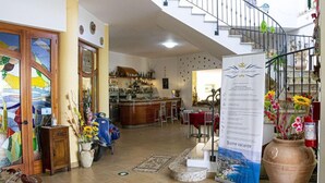 A hotel lobby with a reception desk, a staircase, and a signboard. - Hotel Incoronato (Capo Vaticano)