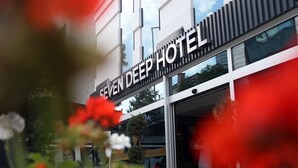 The exterior of the Seven Deep Hotel with a modern architectural design, featuring a prominent sign and a glass facade. - Seven Deep Hotel (Ankara)