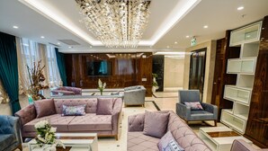 A modern living room with plush sofas, a coffee table, and a chandelier. - Seven Deep Hotel (Ankara)