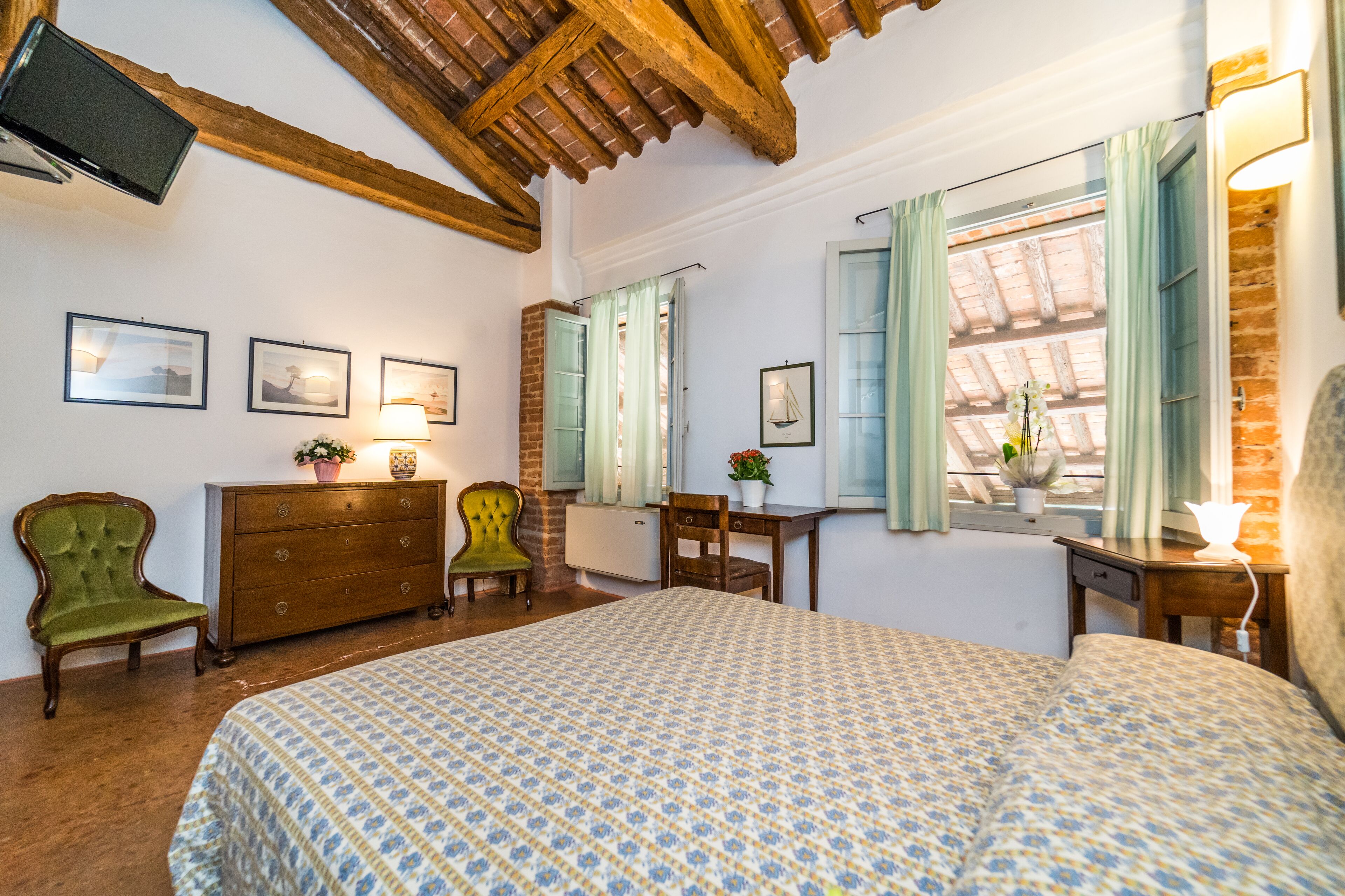 A bedroom with a bed, dresser, chairs, and a desk.