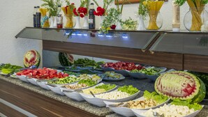 A buffet with various food items and a watermelon carved with "NATRE HOTEL".