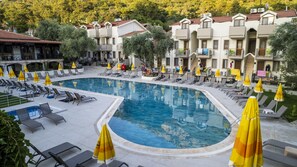 Una piscina al aire libre, sombrillas, tumbonas