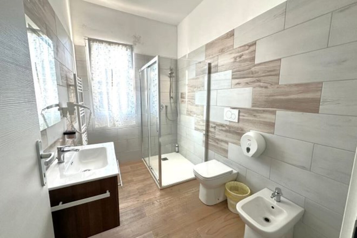 Une salle de bain moderne équipée d’une douche, de toilettes, d’un bidet et d’un lavabo.