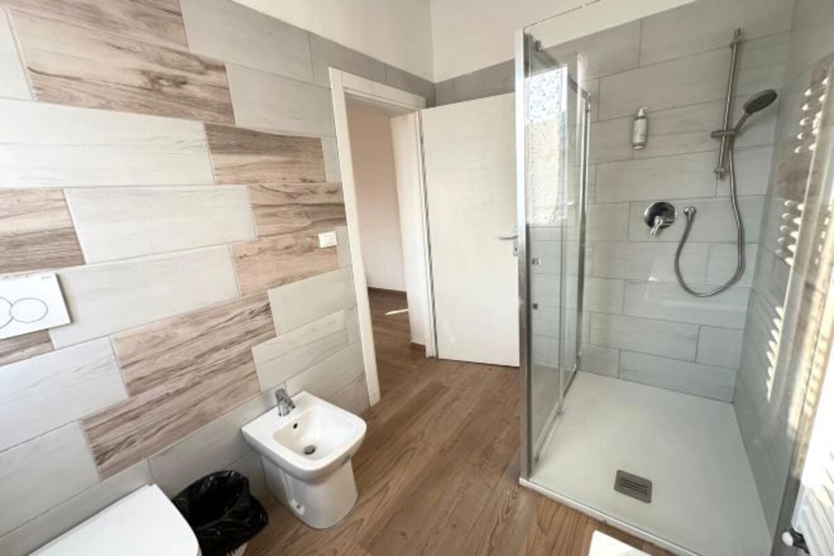 Une salle de bain moderne avec douche, bidet et murs carrelés.