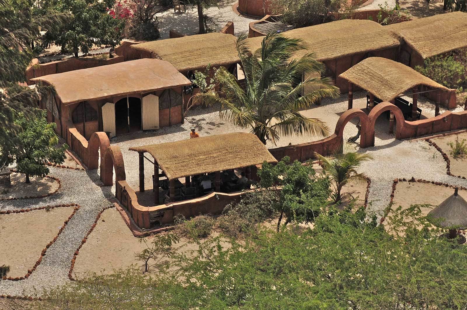 A traditional village with thatched-roof structures, arranged in a circular pattern around a central courtyard.